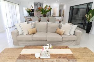 a living room with a couch and a table at Villa Maasai - Coastal Luxury With a Heated Pool in Trinity Beach