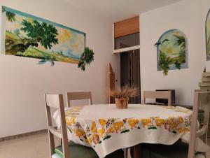 una sala da pranzo con tavolo e un dipinto sul muro di Villa d'Arte a Maruggio