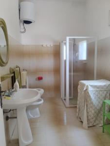 bagno con 2 servizi igienici, lavandino e doccia di Villa d'Arte a Maruggio