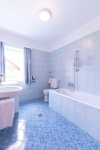 een badkamer met een bad, een toilet en een wastafel bij Appartment Isabelle in Presseggersee