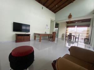 sala de estar con sofá y TV de pantalla plana en Nirosha Guest House en Galle