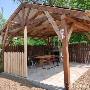 a wooden pavilion with a picnic table and a grill at Apartament pod Lipą in Kłodzko
