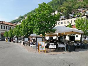 een straat met tafels, stoelen en parasols bij Golden Lake in Como
