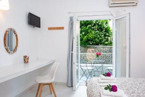 a white room with a bed and a balcony at Averto Corfu Apartments in Dassia