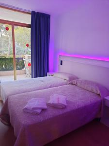 1 dormitorio con 2 camas con iluminación púrpura en la casita de salou, en Salou