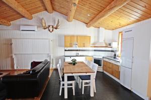 cocina y comedor con mesa y sofá en Saiva Camping & Stugby, en Vilhelmina