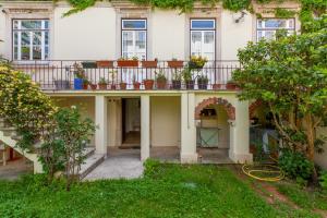 a house with a balcony with potted plants on it at Sky Accommodations family Studios and Suites in Coimbra