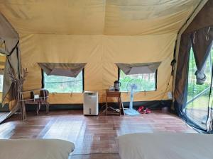 a room with a tent with a fan and a table at Traveller Mountain Spring Farm in Beipu