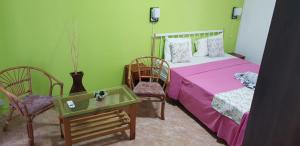 a bedroom with a bed and two chairs and a table at LeBovallon B&B in Mahébourg