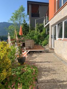 eine Terrasse mit einer Bank und einem Regenschirm auf einem Haus in der Unterkunft Ferienwohnung Drachennest mit Sonnenterrasse in Feldkirch