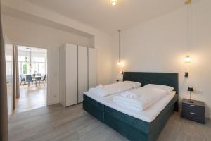 una camera da letto con un letto grande con cuscini bianchi di Meranosuites a Merano