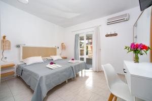 um quarto com 2 camas, uma mesa e cadeiras em Averto Corfu Apartments em Dassia