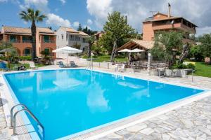 una gran piscina de agua azul frente a una casa en Averto Corfu Apartments, en Dassia