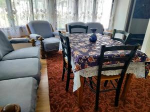 een eetkamer met een tafel en stoelen en een bank bij Casa Simona in Vişeu de Sus