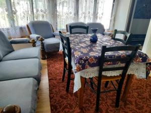a dining room with a table and chairs and a couch at Casa Simona in Vişeu de Sus