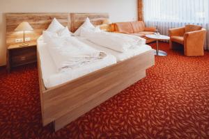 a large bed in a hotel room at Wellnesshotel Sonnenhalde Tonbach in Baiersbronn