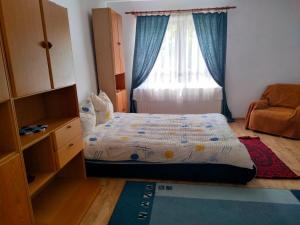 een kleine slaapkamer met een bed en een raam bij Casa Simona in Vişeu de Sus