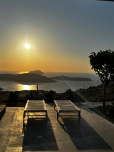 two beds sitting on a ledge with the sunset in the background at Serifos Blue in Rámos