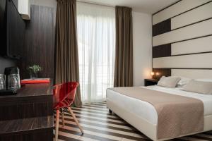 um quarto de hotel com uma cama e uma secretária em Dan Hotel em Riccione