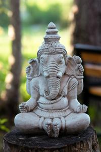 a statue of an elephant sitting on a stump at SHANTI FOREST HOUSE Guest house with mirror sauna 