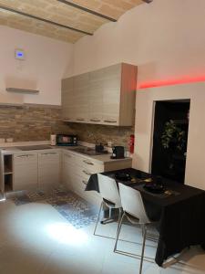 a kitchen with a black table and white cabinets at Sassi di Matera Dimora Sovrana - Deluxe Suite in Matera
