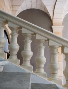 una scala con colonne bianche e scala a chiocciola di Mulberry Suites a La Valletta