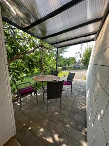 a patio with a table and chairs under awning at Apartman Cvjetni in Njivice