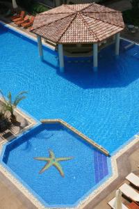 a swimming pool with a blue umbrella on top of it at Aparthotel Dawn Park in Sunny Beach