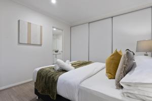 a bedroom with a large bed with white sheets and yellow pillows at The Zen Den Retreat Gateway to the Swan Valley in Perth