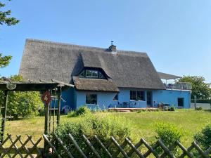 una casa azul con techo de paja en Ferienhaus Mü, en Rankwitz
