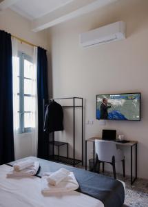 una camera d'albergo con letto, scrivania e TV di Mulberry Suites a La Valletta