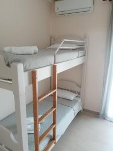 two bunk beds in a small room with a ladder at Dimitris appartment in Stavros