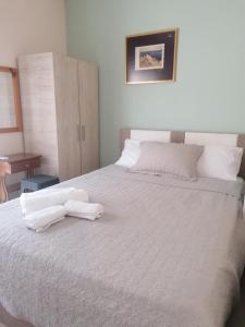 a bedroom with a white bed with two towels on it at Dimitris appartment in Stavros
