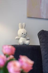 un conejo de peluche sentado en la parte trasera de un sofá en Bright Apartment, en Liubliana