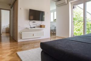 a bedroom with a flat screen tv on a wall at Bright Apartment in Ljubljana +20 photos