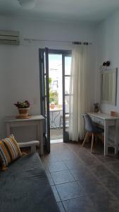 un soggiorno con divano, tavolo e scrivania di Saint George Family Studio a Naxos Chora
