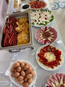 une table recouverte de assiettes de nourriture avec des œufs et de la viande dans l'établissement Oasis The Villa, à Durrës