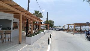 una strada con ristorante e bar con macchine parcheggiate di Saint George Family Studio a Naxos Chora