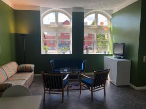 ein Wohnzimmer mit einem Sofa, einem Tisch und Stühlen in der Unterkunft Den lille Skole - Ferie på Ærø i Marstal by in Marstal