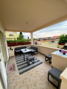 a patio with a table and chairs on a balcony at LuMar Holidays and Apartments in Preko