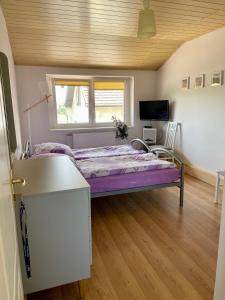 sypialnia z fioletowym łóżkiem w pokoju w obiekcie Pokoje z widokiem w mieście Chrzypsko Wielkie