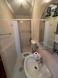 baño con lavabo y aseo con espejo en 100 Meters from the Beach! Rua da Regeneração Nazaré, en Nazaré