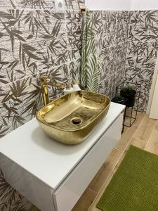 a bathroom with a gold sink on a counter at LuMar Holidays and Apartments in Preko