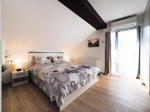 a bedroom with a large bed and a large window at Ben Apartments in Sibiu