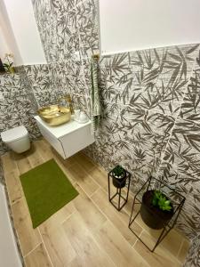 a bathroom with a white sink and a green rug at LuMar Holidays and Apartments in Preko
