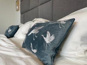 a bed with two pillows with birds on it at Jimmy's Place - Hotelgefühl, Tolle Lage, Terrasse, BBQ in Bad Zwischenahn
