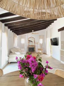 un soggiorno con tavolo e fiori viola di Casa Bonavida a Denia