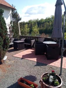 a patio with an umbrella and a table and chairs at Ferienwohnungen direkt am See mit Einzelnbetten in Waldeck