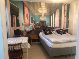 2 Betten in einem Zimmer mit grünen Wänden und Kronleuchtern in der Unterkunft Studio in the center with free private parking in Kemi