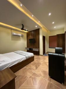 a bedroom with a bed and a flat screen tv at Hotel iris in Nārnaul